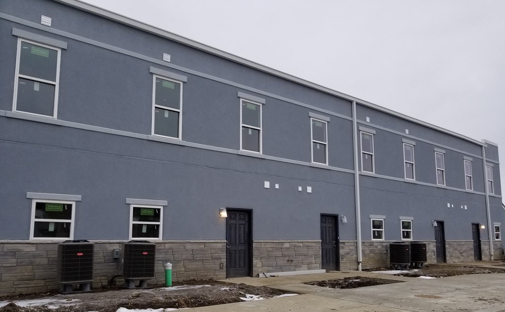 the side of a blue building with windows and doors