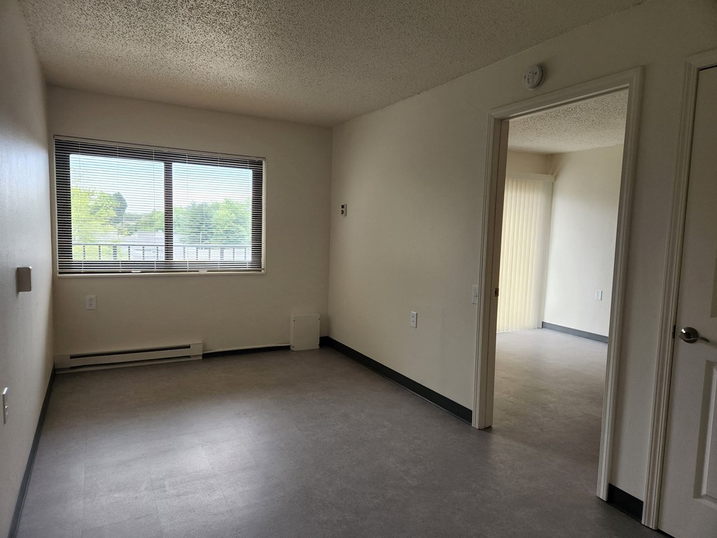 an empty living room with a large window