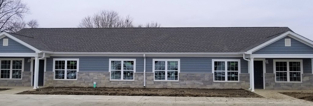 the front of a blue house with white pillars and windows