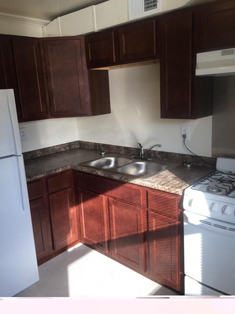 a kitchen with wooden cabinets and a stove and a sink