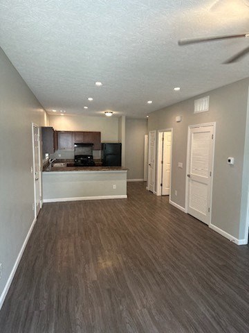 an empty living room and kitchen with a wood floor