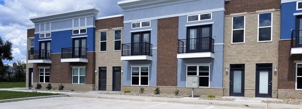 a row of brick and blue apartment buildings on a street