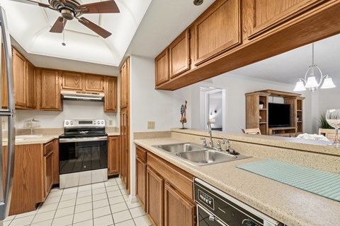 A kitchen with wooden cabinets and a tile floor at Hampton Apartments, Clearwater, FL