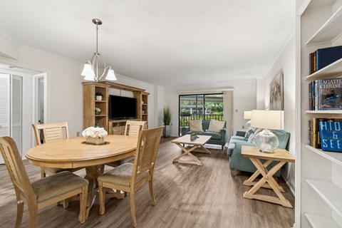 A well-lit, spacious dining room with a wooden table and chairs at Hampton Apartments, Clearwater 33759