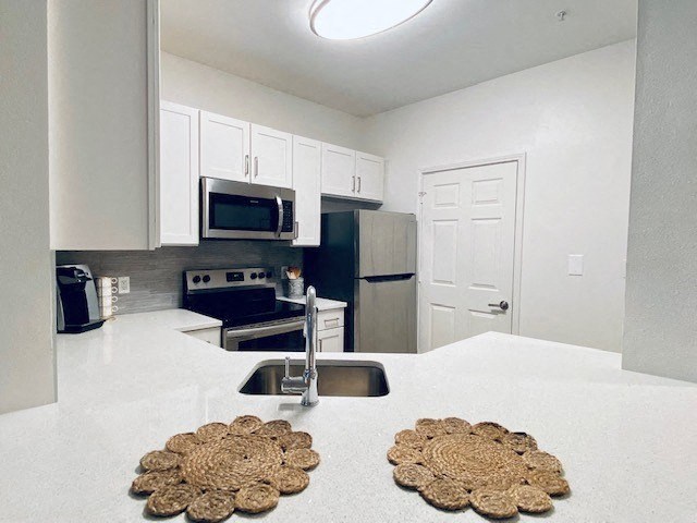 white kitchen with a sink and a microwave at Mainstreet Apartments, Florida, 33756