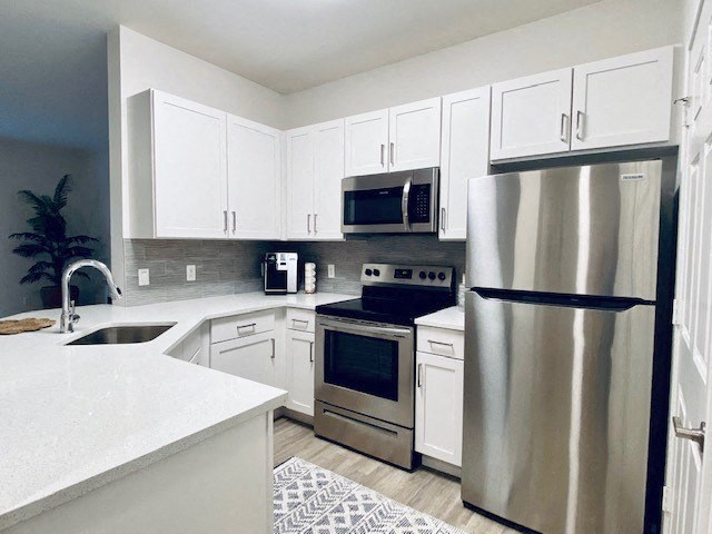 kitchen with stainless steel appliances and white cabinets at Mainstreet Apartments, Florida
