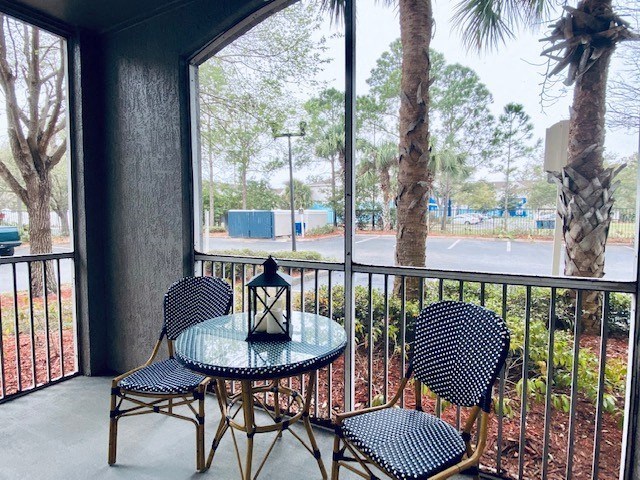 balcony with a table and chairs and a large window at Mainstreet Apartments, Clearwater, Florida
