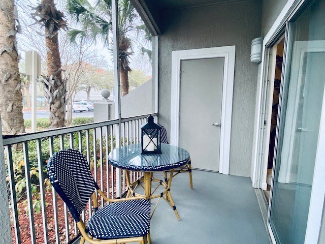 balcony with two chairs and a table and a door at Mainstreet Apartments, Clearwater