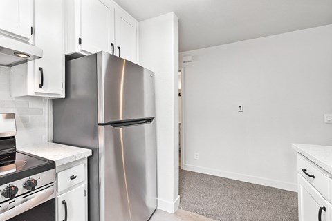 A kitchen with a stainless steel refrigerator and oven.