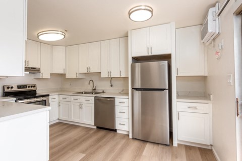 a kitchen with white cabinets and a stainless steel refrigerator