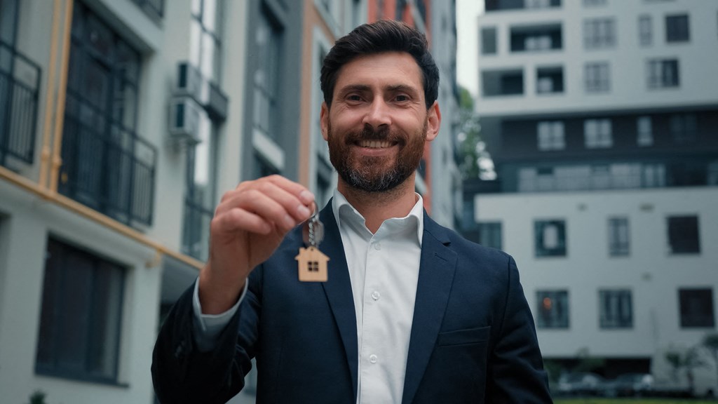 a man wearing a suit and holding a key