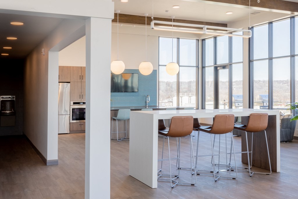 a kitchen and dining area in a modern office space with large windows