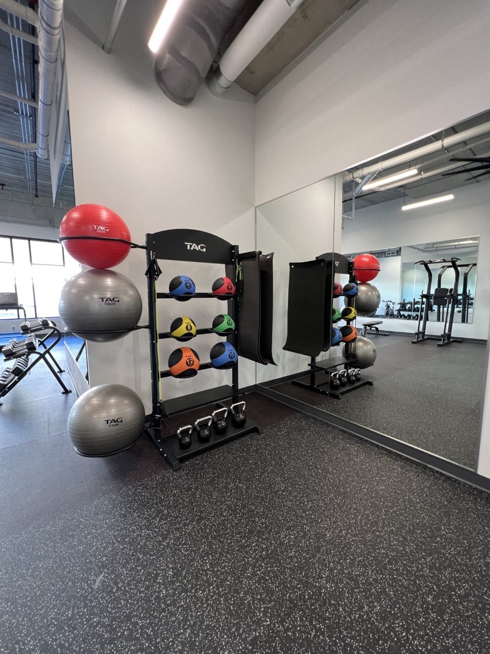 a variety of weights machines and mirrors in a gym