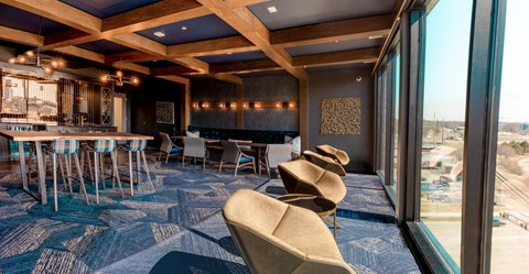 a room with chairs and tables and a large window