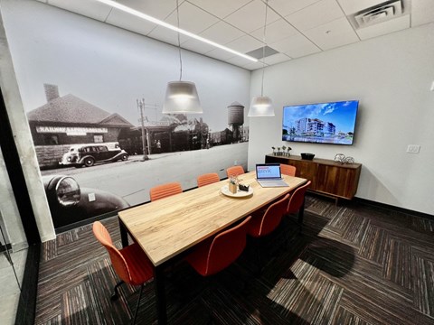 a conference room with a wooden table and red chairs
