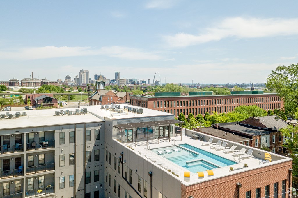 the pool on the roof of a building with a city in the background