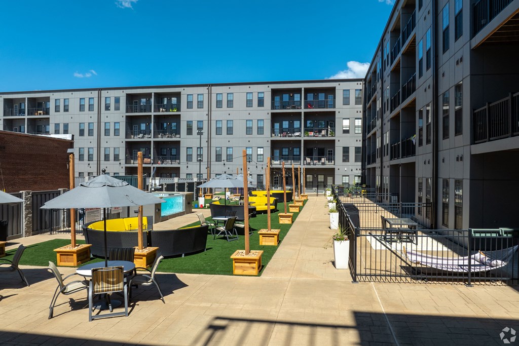 a view of the courtyard of an apartment building with tables and chairs