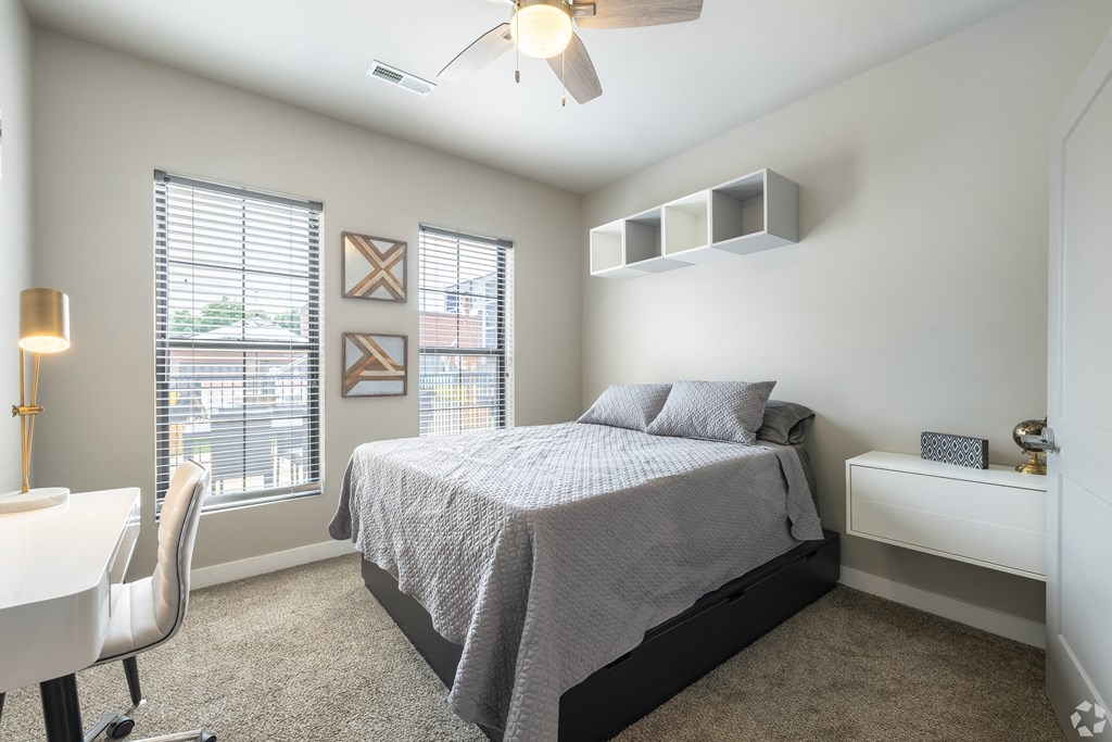 a bedroom with a bed and a desk with a chair