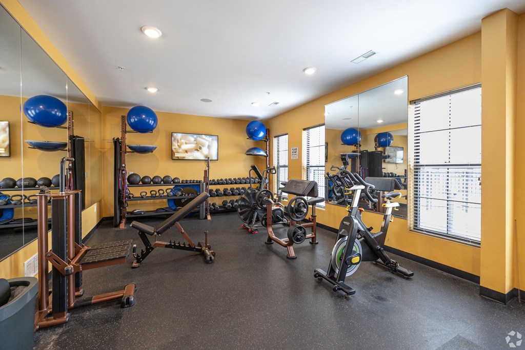 a gym with exercise equipment and mirrors on the wall