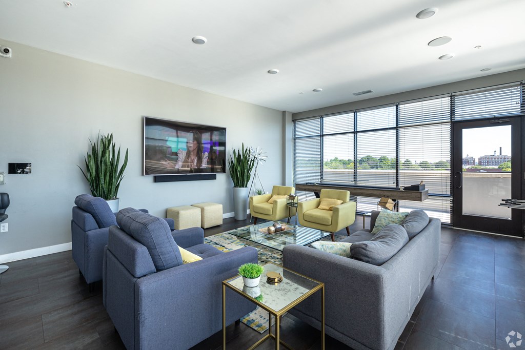 a living room with couches and chairs and a television on the wall