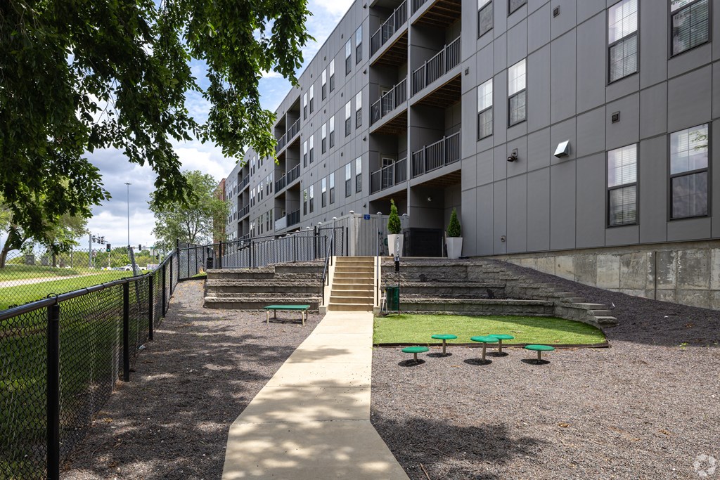 an apartment building with stairs and grass in front of it