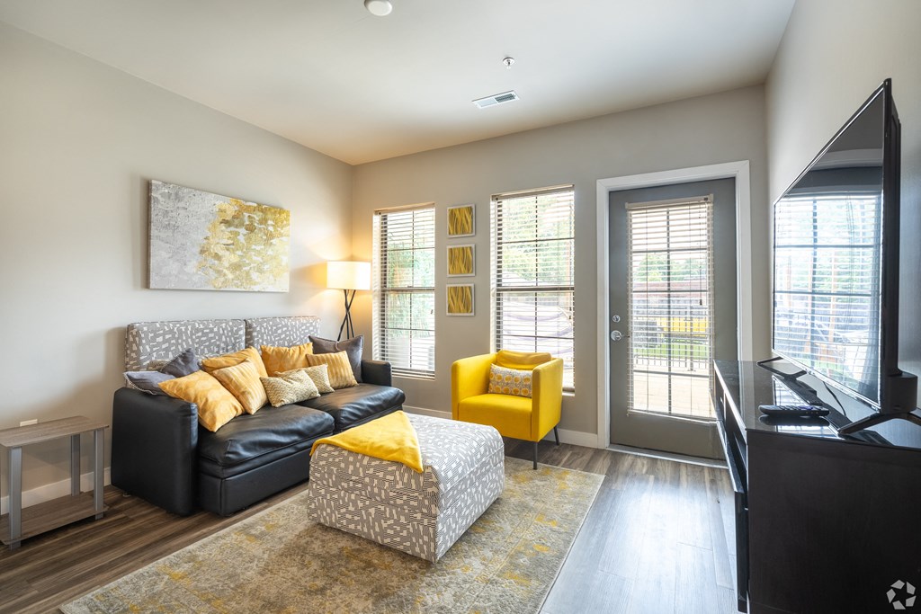 a living room with a couch and a chair and a tv