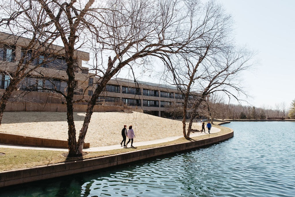people walking on a path near a body of water at The Residences at Tesson Ridge, Missouri