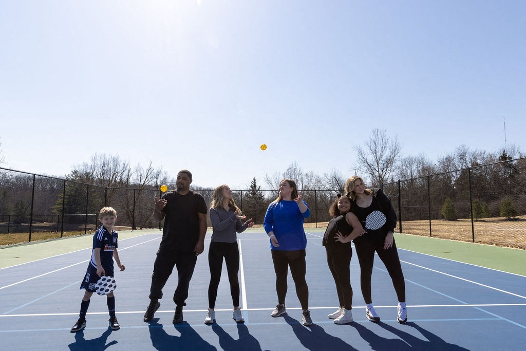 a group of people playing tennis on a tennis court at The Residences at Tesson Ridge, Saint Louis, 63128