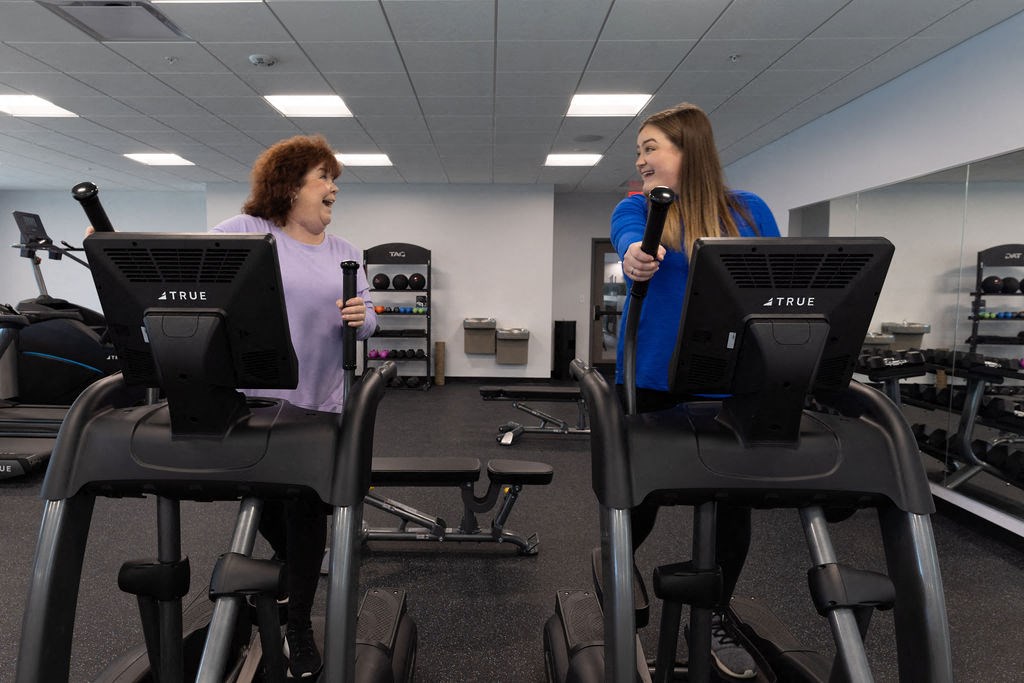 two women on exercise machines in a gym at The Residences at Tesson Ridge, Saint Louis, MO, 63128