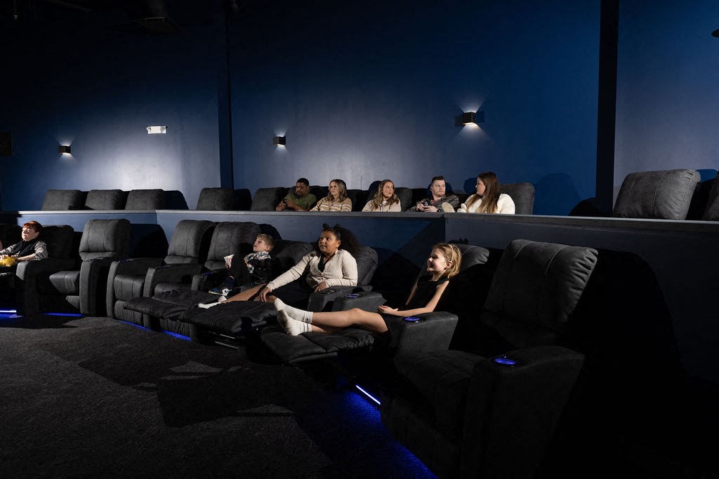 a crowd of people watching a movie in a darkened movie theater at The Residences at Tesson Ridge, Saint Louis, Missouri