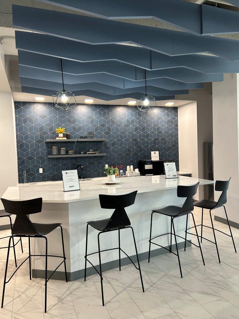 a lobby with a counter and chairs and a blue ceiling at The Residences at Tesson Ridge, Saint Louis, 63128