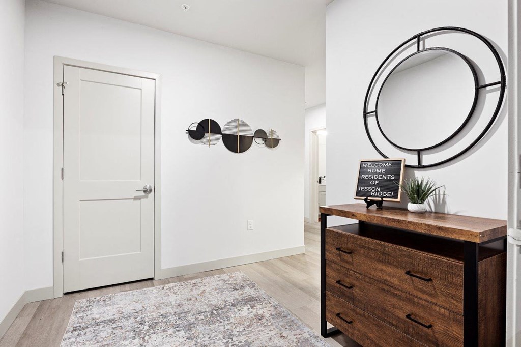 a hallway with a mirror and a dresser at The Residences at Tesson Ridge, Saint Louis