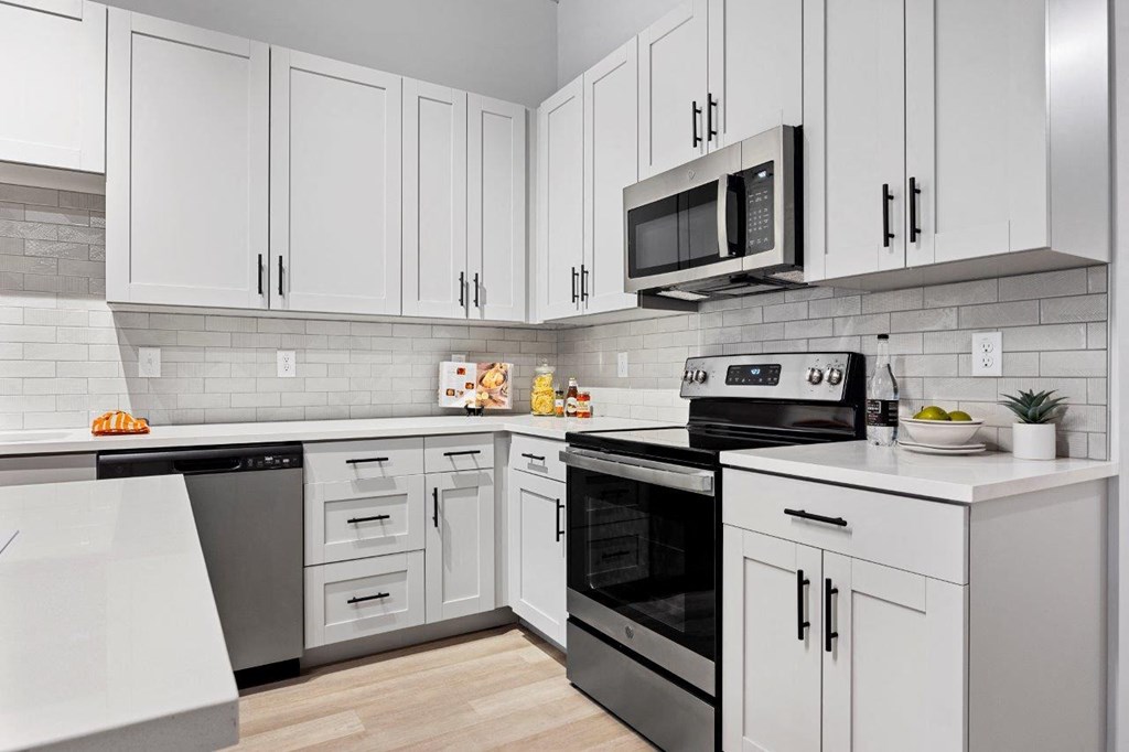 a kitchen with white cabinets and black appliances at The Residences at Tesson Ridge, Saint Louis, 63128