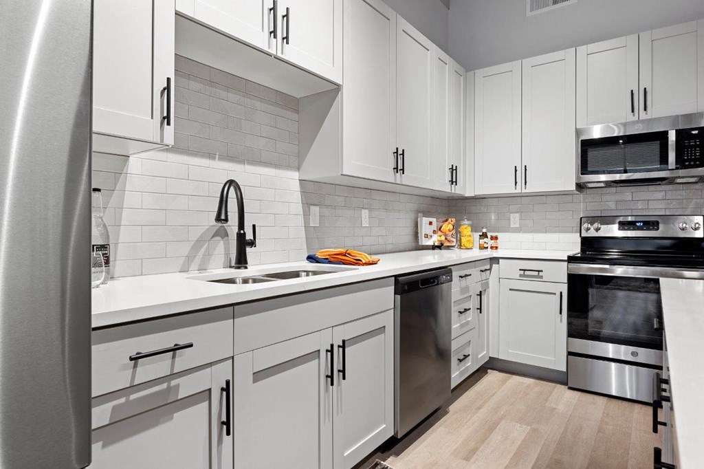 a kitchen with white cabinets and stainless steel appliances at The Residences at Tesson Ridge, Saint Louis, Missouri