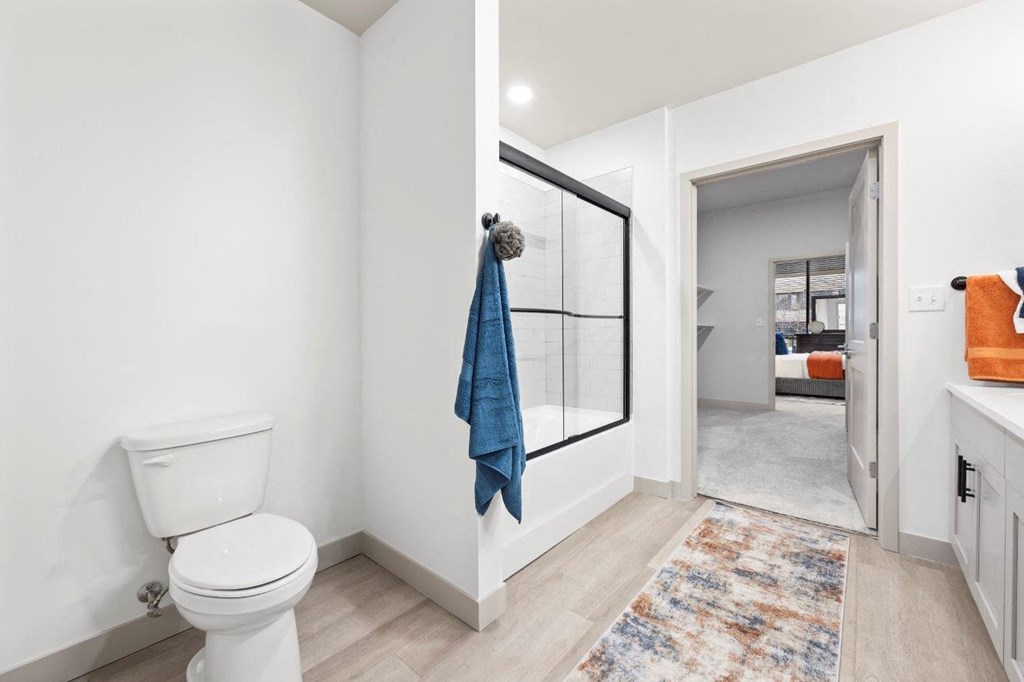 a bathroom with a toilet and a glass shower at The Residences at Tesson Ridge, Saint Louis, MO, 63128