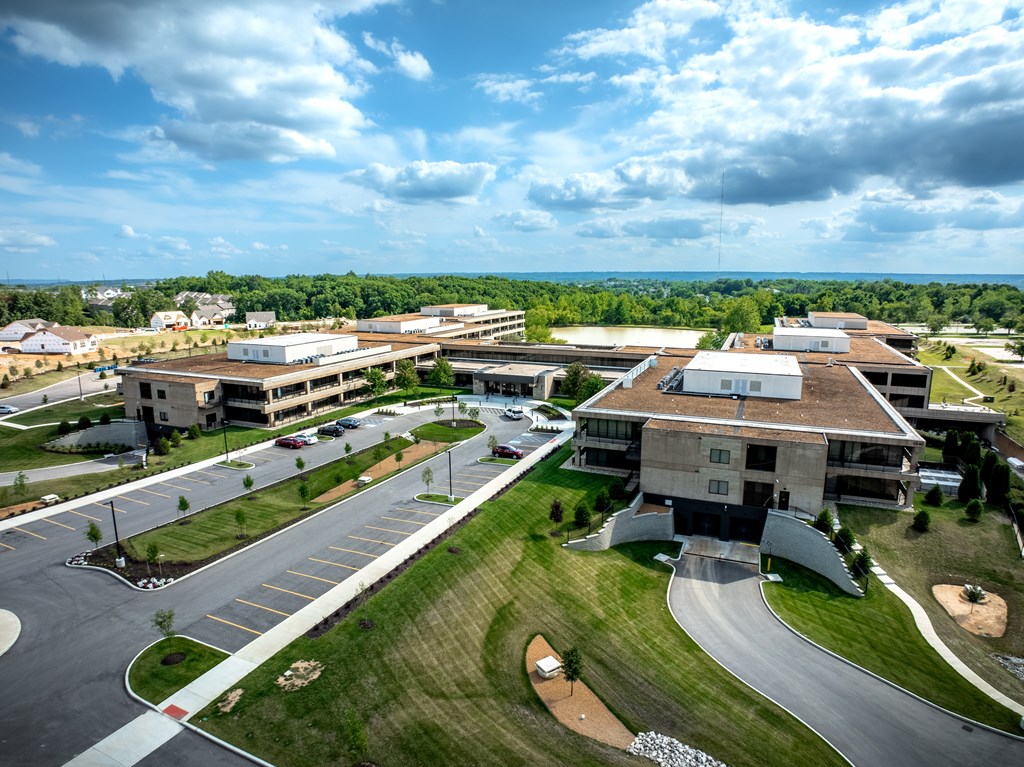 A large building complex with a parking lot in front.