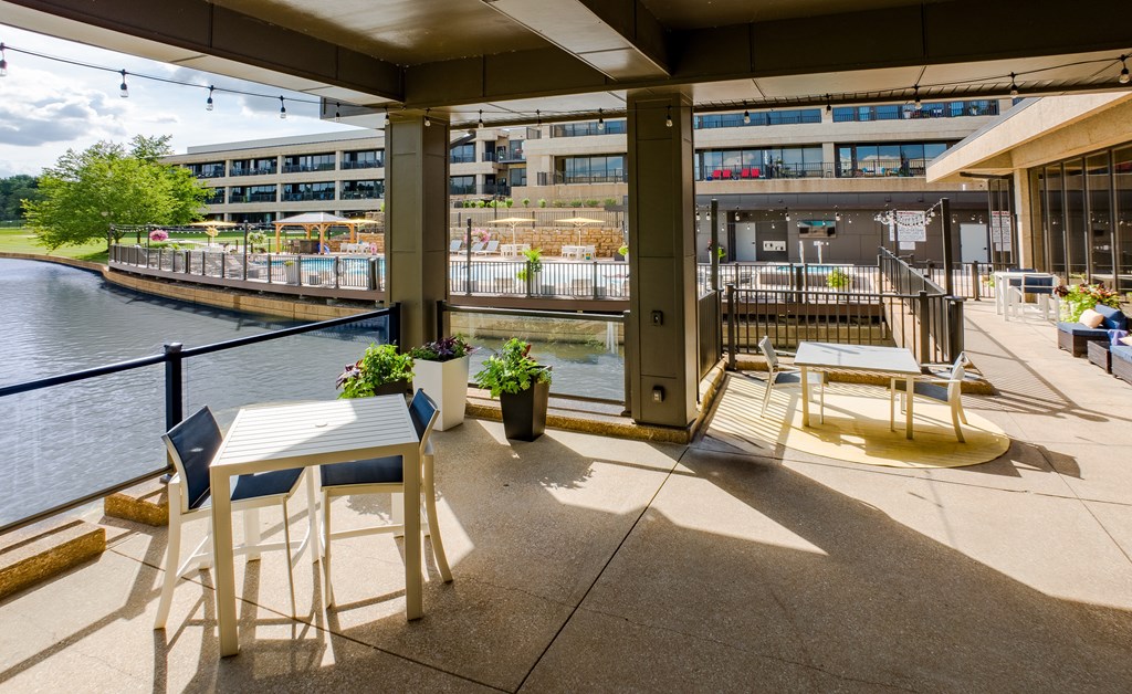 A patio with a table and chairs overlooking a river.