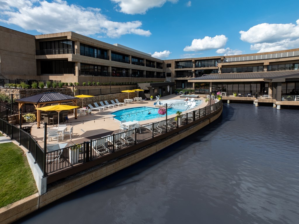 A large building with a pool and a waterway in front.