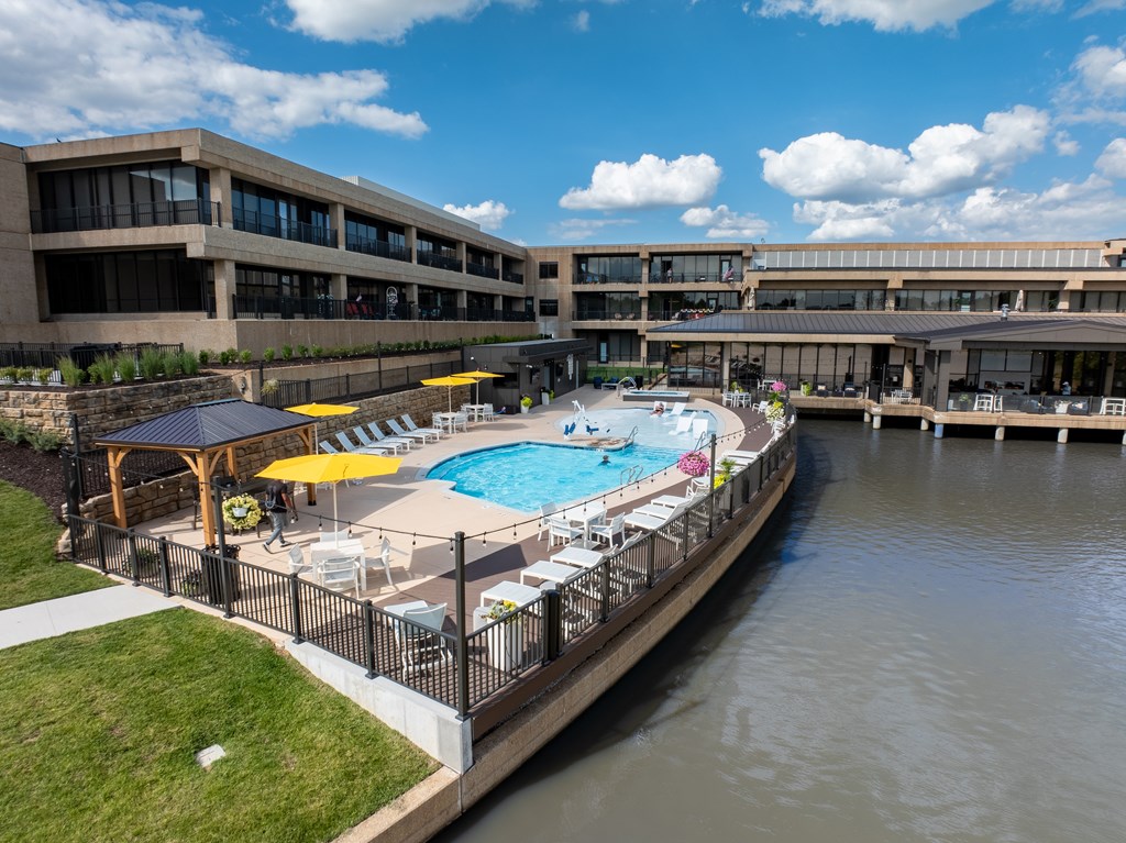 A pool surrounded by a fence and umbrellas.