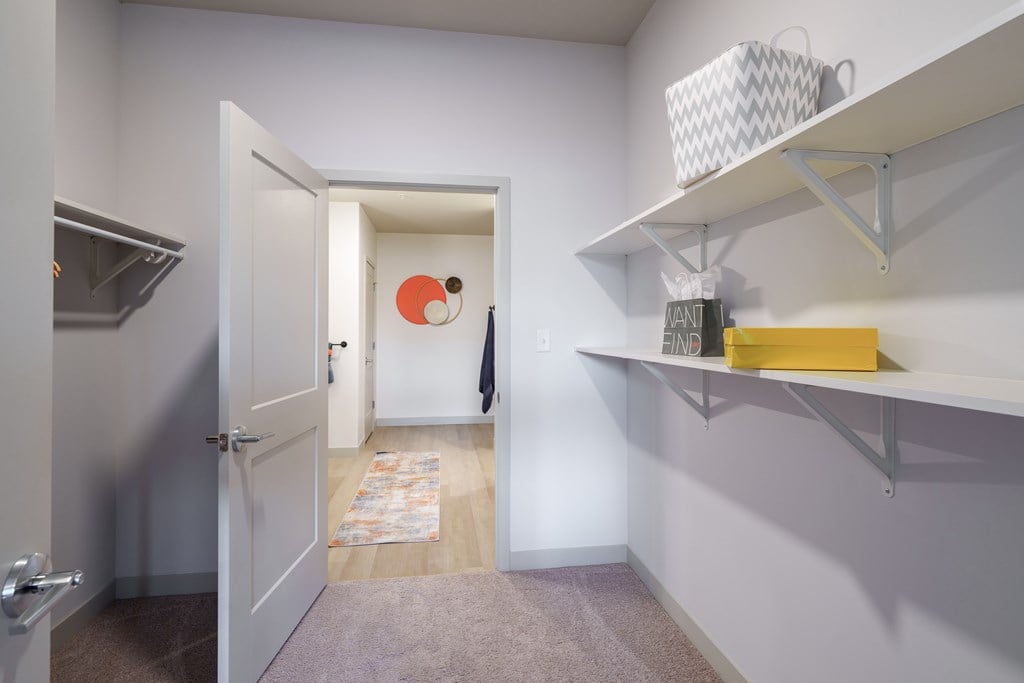 A hallway with a white door and a yellow box on a shelf.