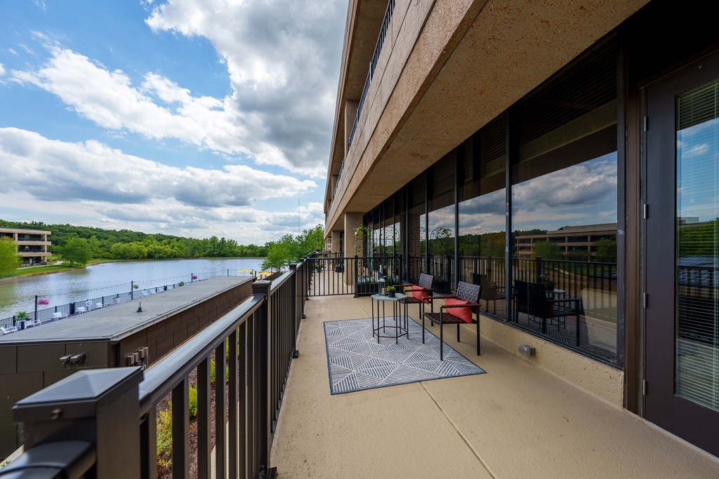 A patio with a table and chairs overlooking a river.