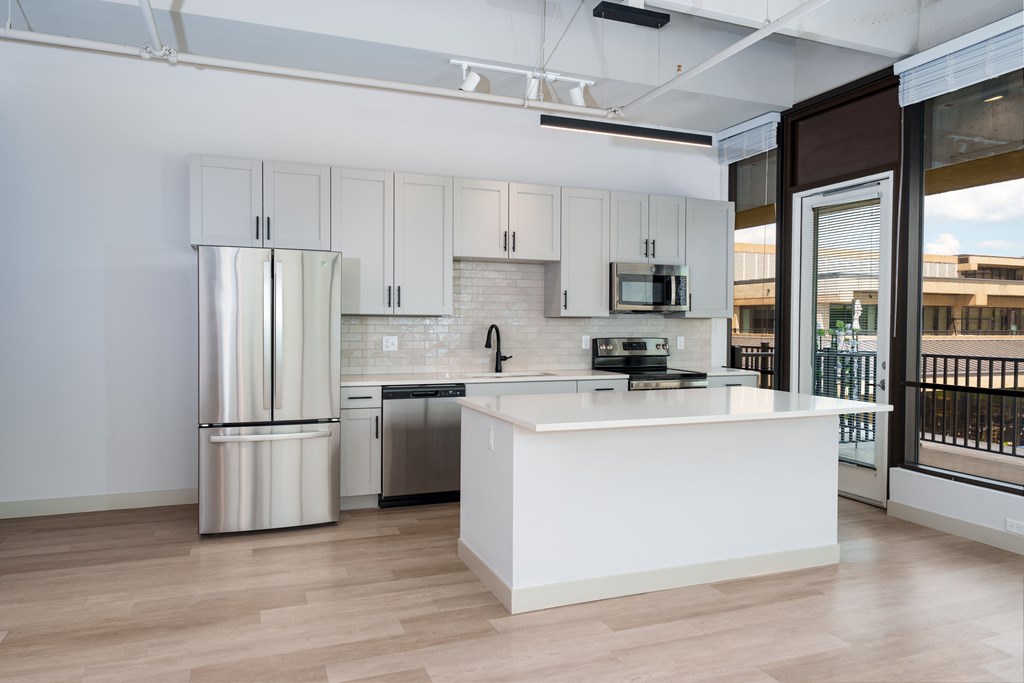 A modern kitchen with white cabinets and stainless steel appliances.