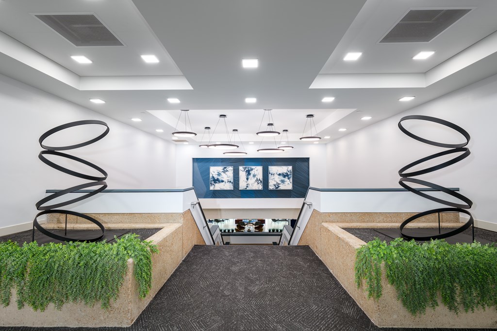 A room with a grey carpet and two green plants on concrete blocks.