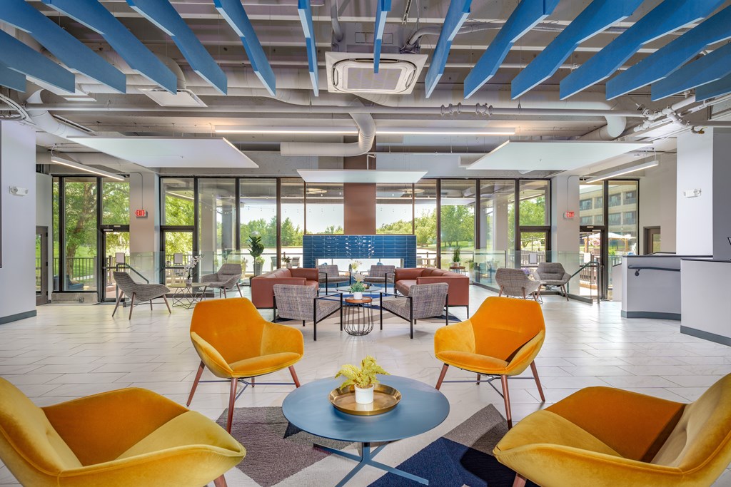 A modern room with yellow chairs and a blue table.