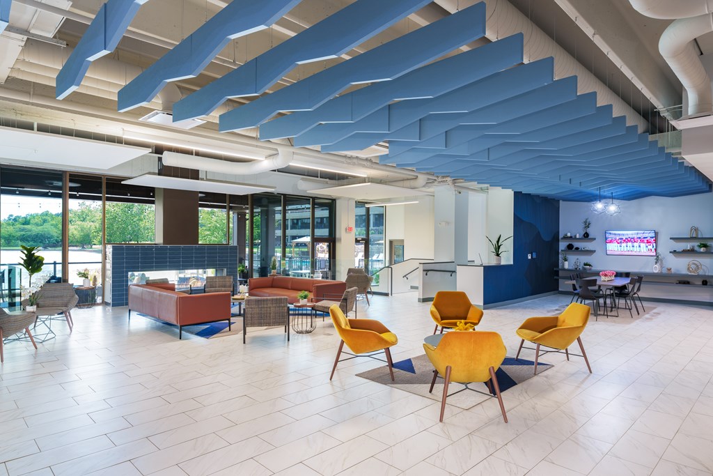A modern open space with yellow chairs and a blue ceiling.