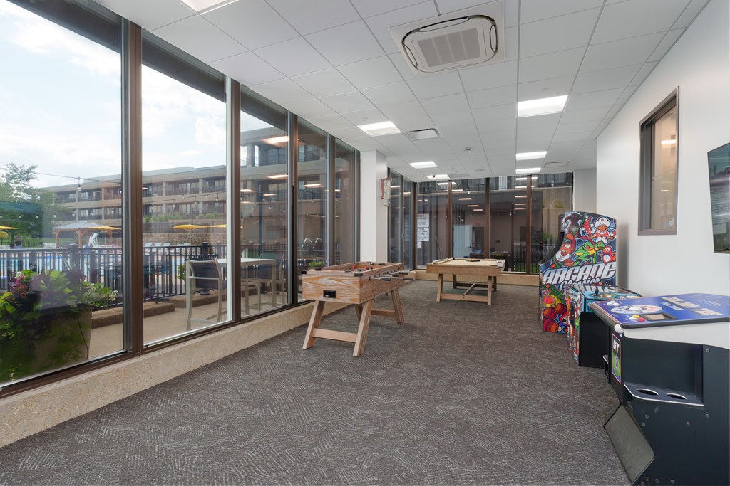 A room with a table and chairs in front of a window.