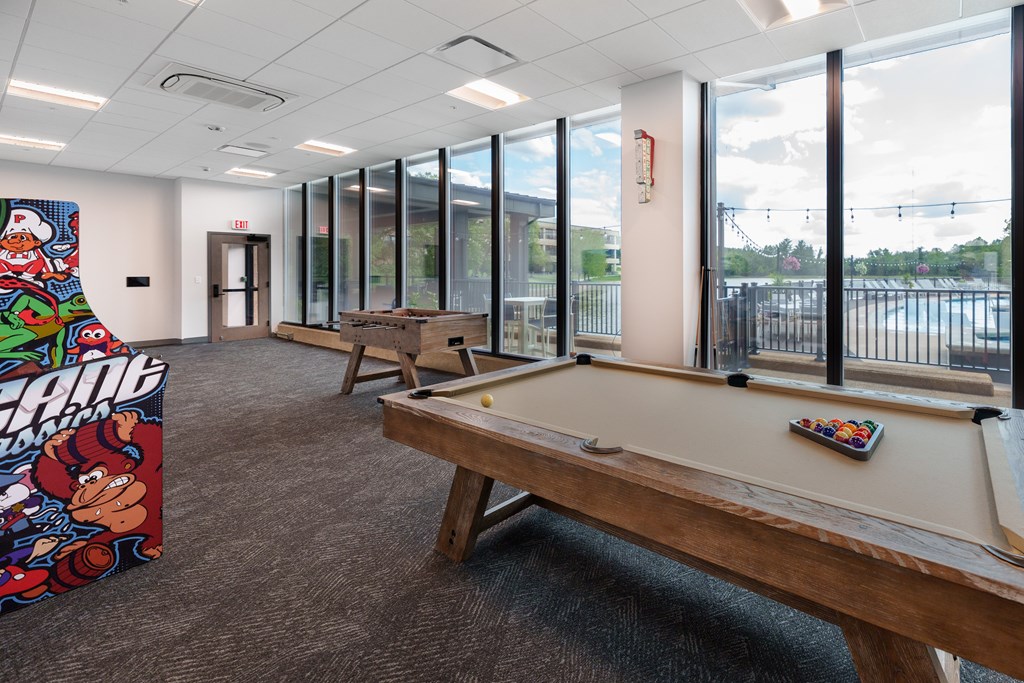 A billiard table in a room with a pool table poster on the wall.
