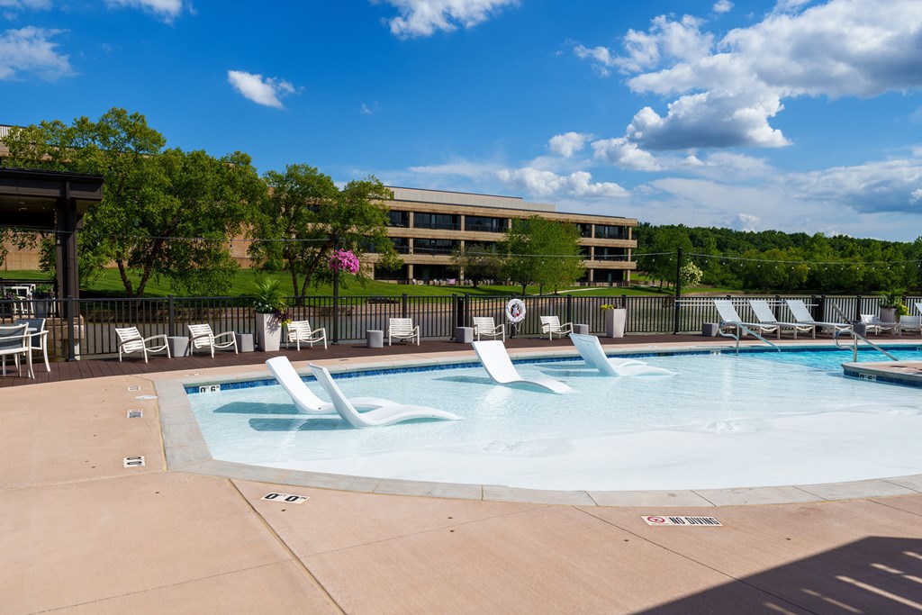 A large outdoor swimming pool with a water slide and lounge chairs.