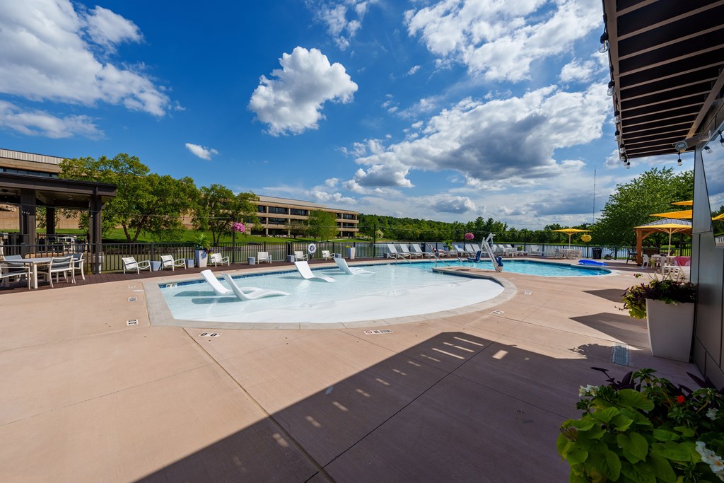 A large outdoor swimming pool with a fountain in the middle.