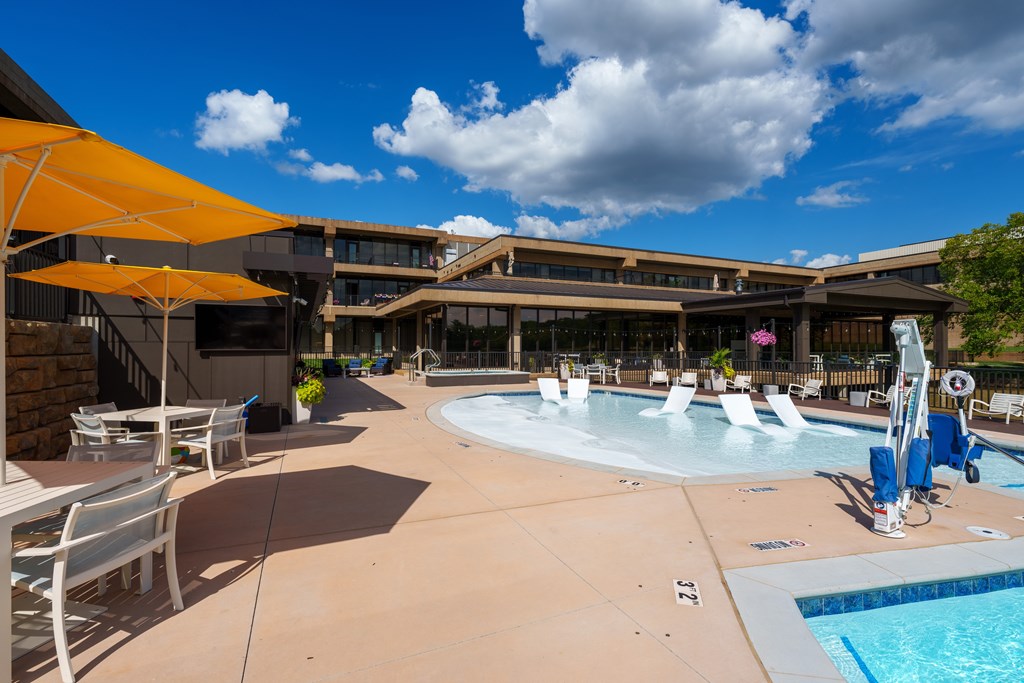 A sunny day at the pool with chairs and umbrellas.